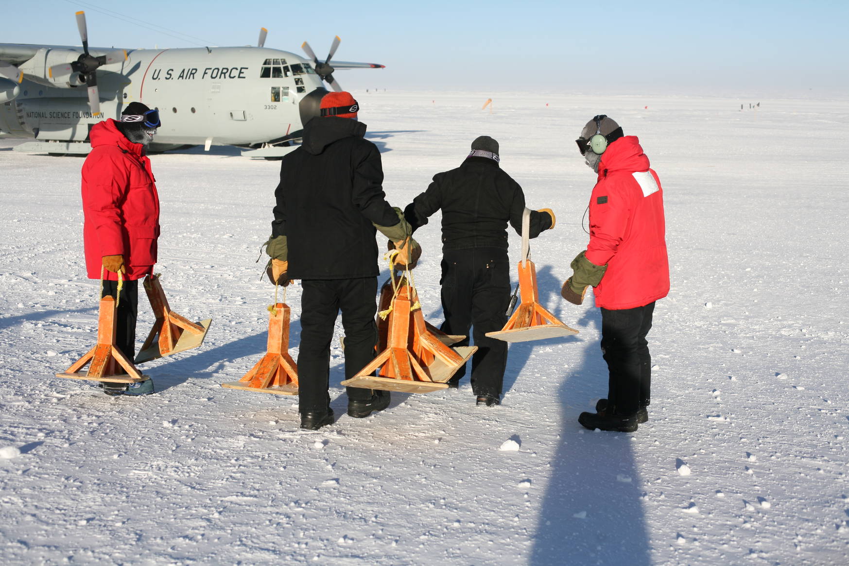 Orange 'cones' to mark a safe path for walking to and from the aircraft. I am one of the people deploying the cones (black jacket orange-red hat).